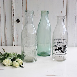 Collection of Three Old Decorative Milk Bottles with Vintage Graphics