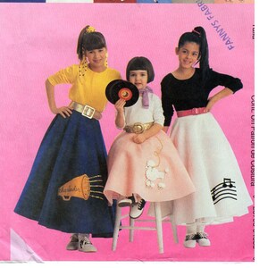 Könnte beinhalten: Drei Mädchen tragen farbenfrohe Kleider im Stil der 50er Jahre mit Poodle-, Noten- und Megaphon-Designs. Die Mädchen tragen gelbe, weiße und schwarze Oberteile. Der Hintergrund ist rosa.