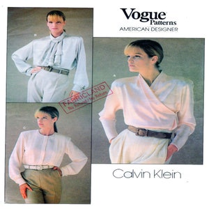 May include: A sewing pattern for a blouse by Calvin Klein. The pattern is from Vogue Patterns, American Designer. The pattern shows three different styles of blouses, all with long sleeves and a collar.