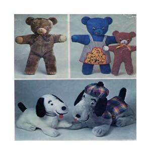 Pode incluir: Quatro brinquedos de pelúcia: um urso de peluche marrom, um urso de peluche azul vestindo um vestido amarelo e branco, um urso de peluche marrom e dois cães, um branco com manchas pretas e um cinza com orelhas pretas e um chapéu xadrez.
