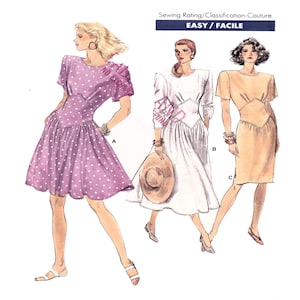 Peut inclure: Un patron de couture pour une robe avec trois variantes. La robe est de style simple et ajusté, avec un décolleté en V et des manches courtes. Le patron comprend des instructions pour réaliser la robe dans trois tissus différents : un imprimé à pois, un tissu blanc uni et un tissu beige uni. Le patron est intitulé "Facile/Facile".