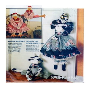 May include: A set of three handmade draft busting doorstops featuring a cow and two chickens. The cow is dressed in a black and white striped dress with a floral print and a white lace trim. The chickens are dressed in red and white gingham dresses. The doorstops are 63.5 cm tall and the little babies are 7.5 cm tall.