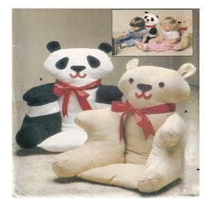 May include: Two plush animal chairs: a panda with black and white fur and a cream-colored bear, both with red ribbon bows. The panda has black ears and eyes. The bear has a cream-colored body and a red mouth.