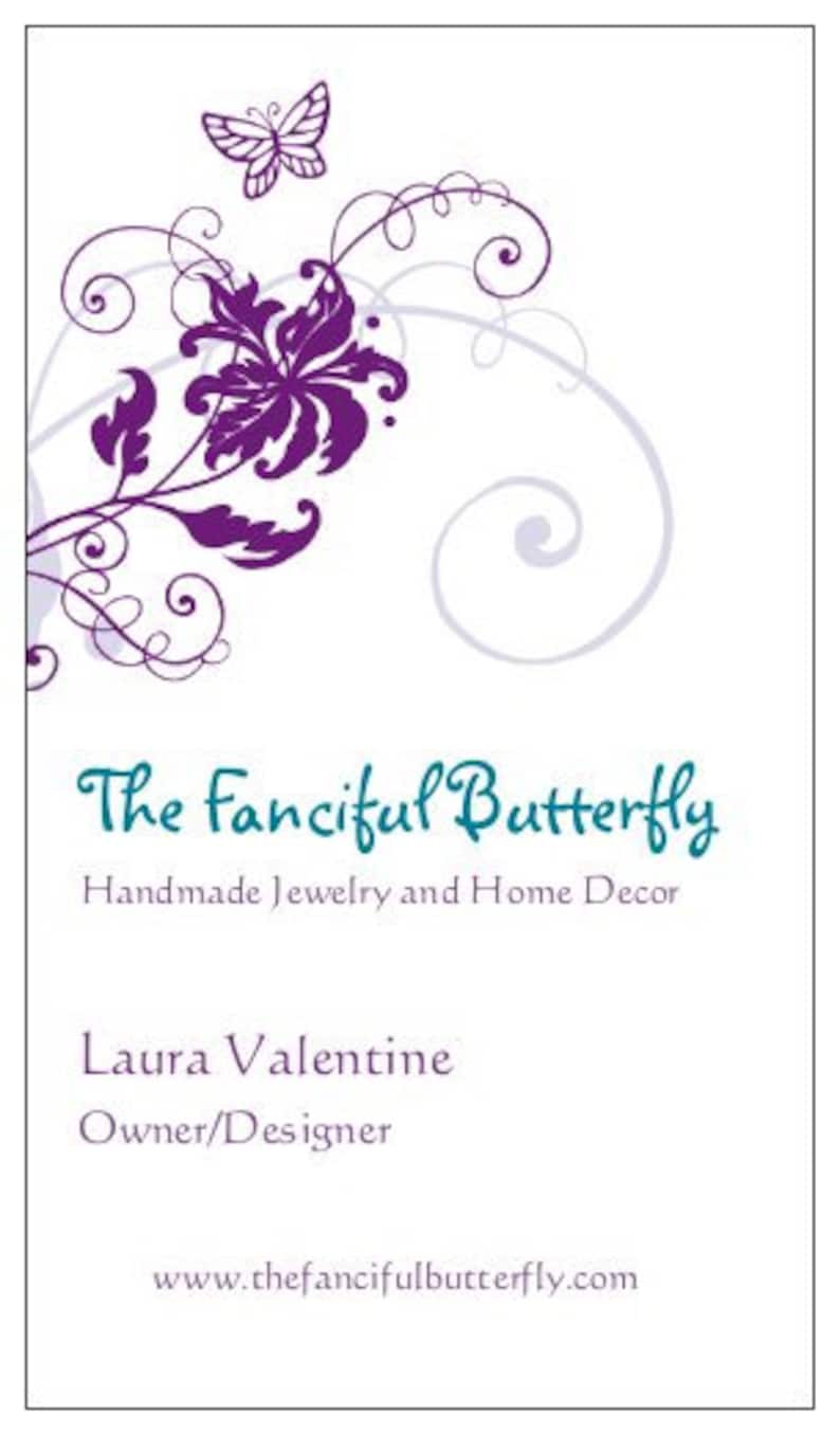 May include: A business card with a white background features a purple floral and butterfly design. The text "The Fanciful Butterfly" is in teal script, with "Handmade Jewelry and Home Decor" below. The owner's name and website are also included.