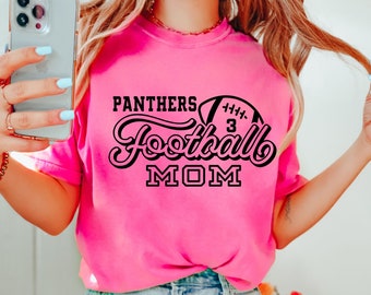 Könnte beinhalten: Pinkes T-Shirt mit schwarzem Text "Panthers Football Mom" und einer schwarzen Football-Grafik mit der Nummer 3.