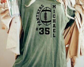 Könnte beinhalten: Grünes T-Shirt mit einem schwarzen Football-Motiv und dem Text "Panthers #35 Michael" auf der Vorderseite.
