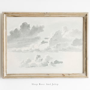 May include: A framed watercolor painting of a cloudy sky in shades of gray and white. The frame is a light wood color with a distressed finish.