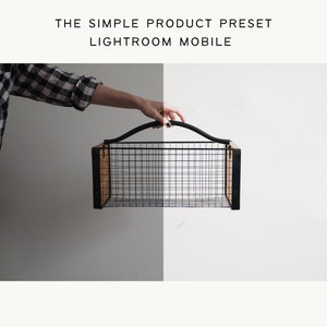 Puede incluir: Una cesta rectangular de alambre con laterales de madera y un asa negra se sostiene sobre un fondo blanco y gris. El texto "THE SIMPLE PRODUCT PRESET LIGHTROOM MOBILE" está en la parte superior.