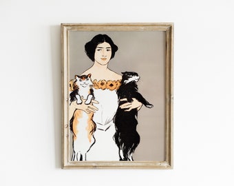 Könnte beinhalten: Ein gerahmtes Vintage-Poster mit einer Frau in einem weißen Kleid, die zwei Katzen hält. Die Frau hat dunkles Haar und trägt eine Blumenkette. Die Katzen sind eine dreifarbige Katze und eine schwarze Katze.
