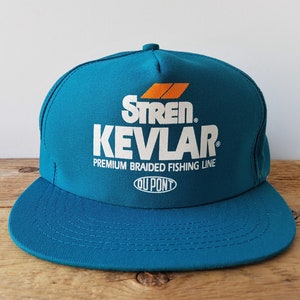 May include: A teal-colored baseball cap with a flat brim. The cap features the text "Stren Kevlar Premium Braided Fishing Line" in white, with an orange and white logo. The brand name "DuPont" is also visible.
