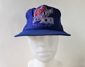 May include: Blue and white baseball cap with a red rose and the text "Super Bowl XXII Rose Bowl - Pasadena January 25, 1987"