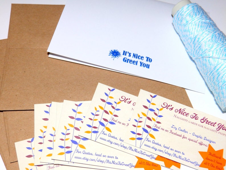 May include: A collection of greeting cards with the text "It's Nice To Greet You" in blue. The cards have a floral design in yellow, purple, and orange. Kraft paper envelopes and a spool of blue and white twine are also visible.