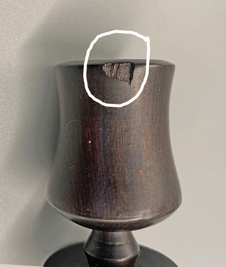 Pode incluir: Um c&aacute;lice de madeira castanho escuro com um pequeno lascado na borda.