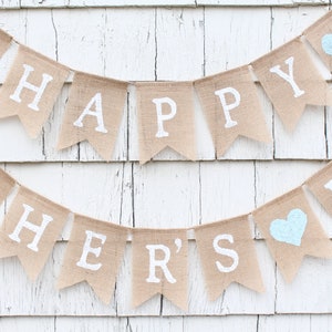 May include: A burlap banner with the words "Happy Father's Day" in white paint. The banner has three blue hearts.