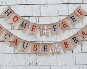 Könnte beinhalten: Ein Banner aus Jute mit dem Text "Home of the Free because of the Brave" in Rot, Weiß und Blau. Das Banner ist an einer weißen Holzwand befestigt.