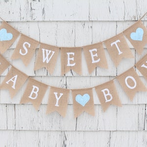 May include: A burlap banner with the words "Sweet Baby Boy" in white lettering. The banner is decorated with blue hearts.