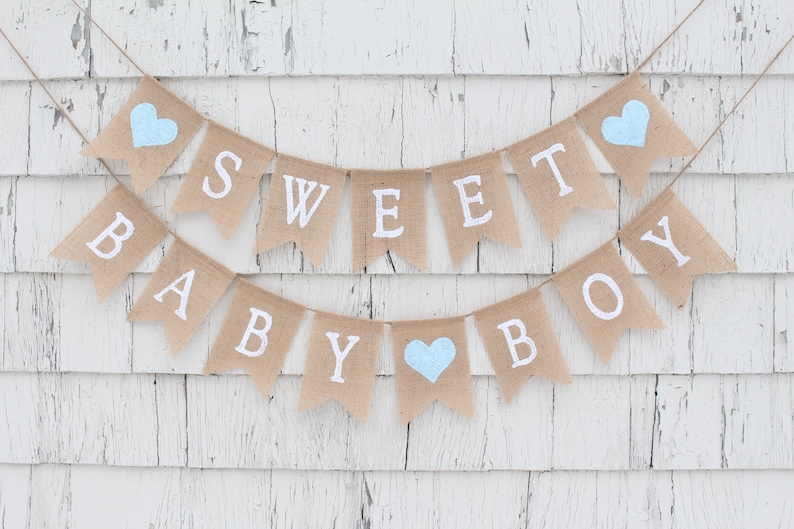May include: A burlap banner with the words "Sweet Baby Boy" in white lettering. The banner is decorated with blue hearts.