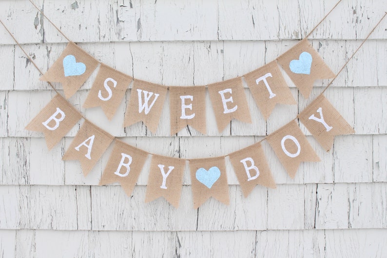 May include: A burlap banner with the words "Sweet Baby Boy" in white letters. The banner is decorated with three light blue hearts.