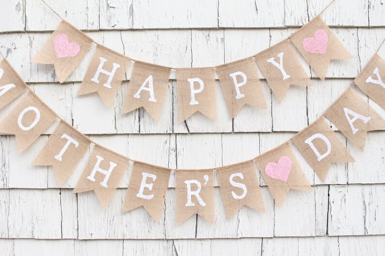 May include: A burlap banner with pink hearts and the text "Happy Mother's Day" in white letters.