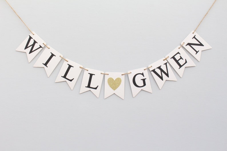 May include: White banner with black letters spelling "WILL LOVE GWEN" with a gold glitter heart in between the words "LOVE" and "GWEN".