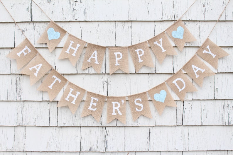 May include: A burlap banner with the words "Happy Father's Day" in white lettering. The banner is decorated with blue hearts.