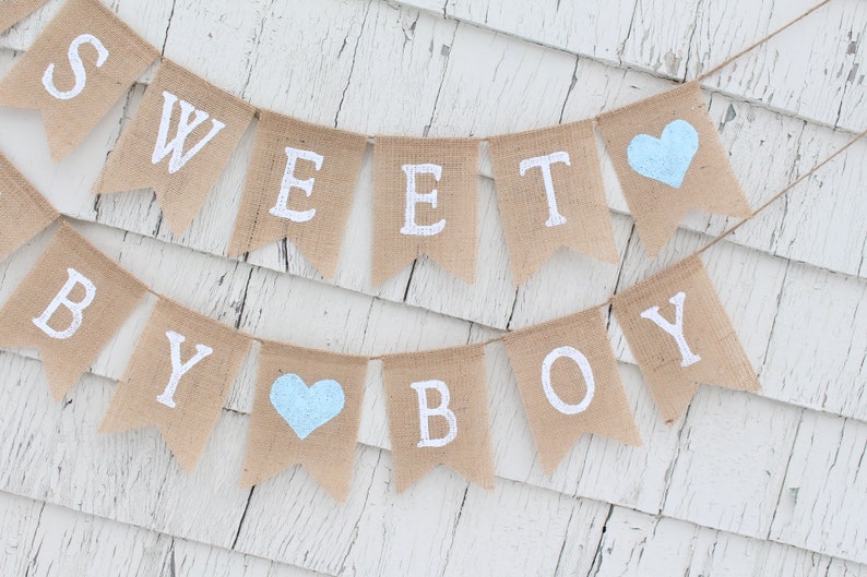 May include: A burlap banner with the words "Sweet Baby Boy" in white paint. The banner has two light blue hearts.