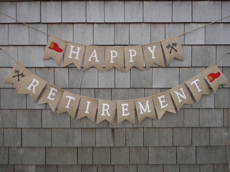 May include: A burlap banner with the words "Happy Retirement" in white lettering. The banner is decorated with red firefighter hats and crossed axes.