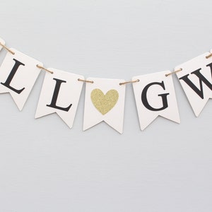 May include: White banner with black letters spelling "WILL LOVE" with a gold glitter heart in between the words.