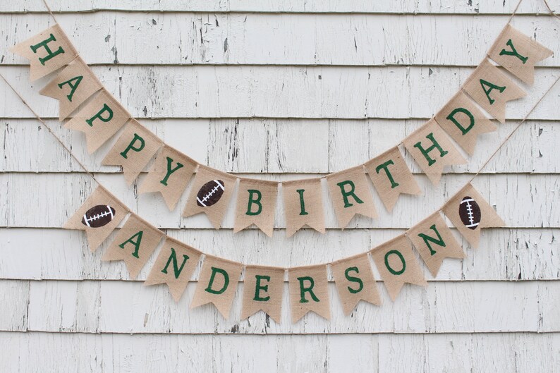 May include: A burlap banner with green letters spelling "Happy Birthday Anderson" with football graphics on each end.