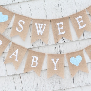 May include: A burlap banner with the words "Sweet Baby Boy" in white lettering. The banner is decorated with two light blue hearts.