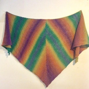 May include: A triangular crocheted shawl with a colorful ombre pattern in shades of purple, green, orange, and yellow.