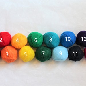 May include: Thirteen felt balls in a rainbow color pattern, numbered 1 through 13.