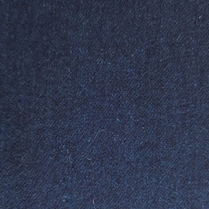 May include: Close-up of dark blue denim fabric with a woven texture.