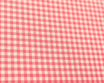 Może przedstawiać: Tkanina z powtarzającym się wzorem w kratkę vichy, składająca się z małych, jednolitych kwadratów w naprzemiennych odcieniach jasnego koralowego różu i czystej bieli, tworząca spójny i zrównoważony geometryczny wzór siatki na powierzchni.