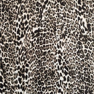 May include: Close-up of a fabric with a leopard print pattern. The pattern features black, brown, and gray spots on a white background. The spots vary in size and shape, creating a textured appearance. This fabric is suitable for clothing or home decor.