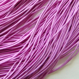 May include: A bundle of thin, light purple elastic cord. The cord is smooth and appears to be made of a soft material.