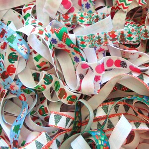 May include: A collection of colorful Christmas-themed elastic ribbon with various patterns, including trees, snowflakes, and ornaments.