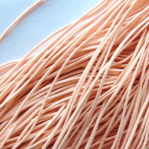 May include: A bundle of peach-coloured elastic cord, ideal for crafting and jewellery making.