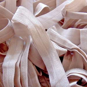 May include: A pile of beige elastic fabric, likely for sewing or crafting projects.
