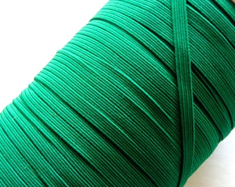 May include: A spool of bright green elastic cord, wound tightly and ready for use in sewing or crafting projects.