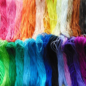May include: A collection of colourful elastic cords in various shades of pink, orange, green, blue, purple, and black.