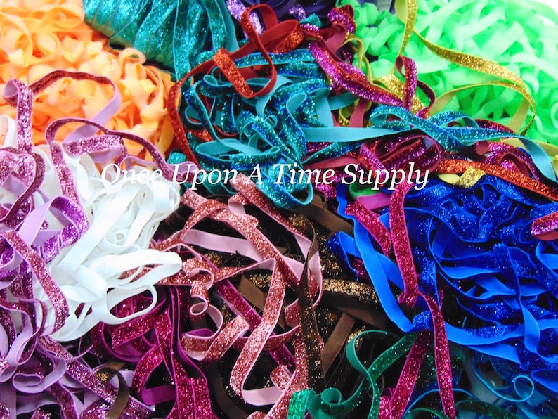 May include: A variety of colorful glitter elastic ribbon. The ribbon is in shades of purple, pink, red, orange, brown, teal, blue, green, and gold.  The ribbon is perfect for adding a touch of sparkle to crafts, hair accessories, and clothing.