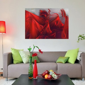 May include: A living room scene featuring a large abstract art piece with flowing red fabric. A gray sofa with green pillows, a black coffee table with fruit, and a red floor lamp complete the decor. A green potted plant adds a natural touch.