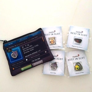 Op de afbeelding: Een zwart en blauw etui met ritssluiting met een game-interface ontwerp, samen met vijf kleine pakketten met het label "BEST IN SLOT". De pakketten bevatten verschillende game-gerelateerde items, waaronder een "Magical Eye Patch" en een "Source of Pain" item.