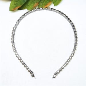 May include: A silver headband with clear rhinestones.