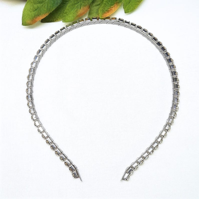 May include: A silver headband with clear rhinestones.