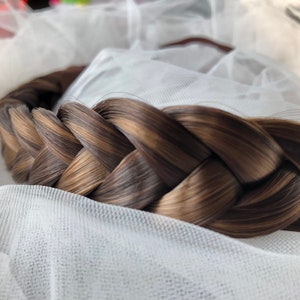 May include: A brown and blonde braided hairpiece, perfect for adding volume and texture to a hairstyle.