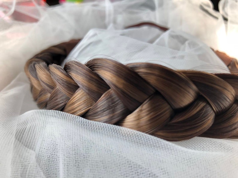 May include: A brown and blonde braided hairpiece, perfect for adding volume and texture to a hairstyle.