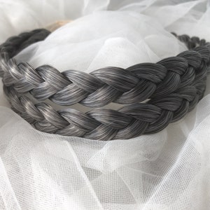 May include: A gray braided headband made from real hair. The headband is double-layered and is shown on a white background.