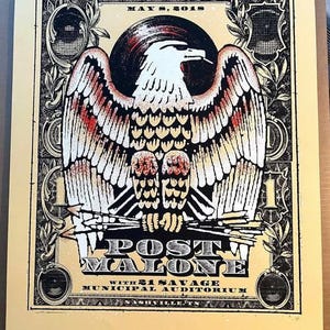 May include: A concert poster featuring a stylized eagle with outstretched wings, in black, white, and red. The poster includes the text "POST MALONE" with "21 SAVAGE" and "MUNICIPAL AUDITORIUM" below. The date "MAY 8, 2018" is at the top.